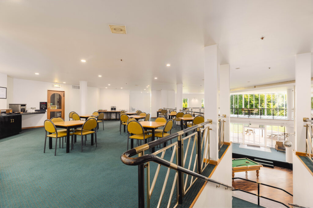 Spacious dining area at Methven Resort with tables, chairs, and natural light from large windows.