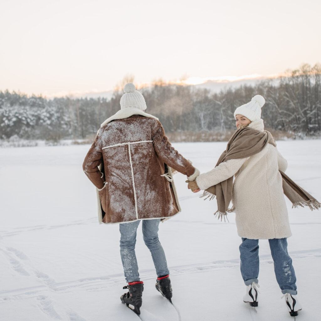 Couple ice skating hand in hand on a frozen lake in winter near Methven, Canterbury.